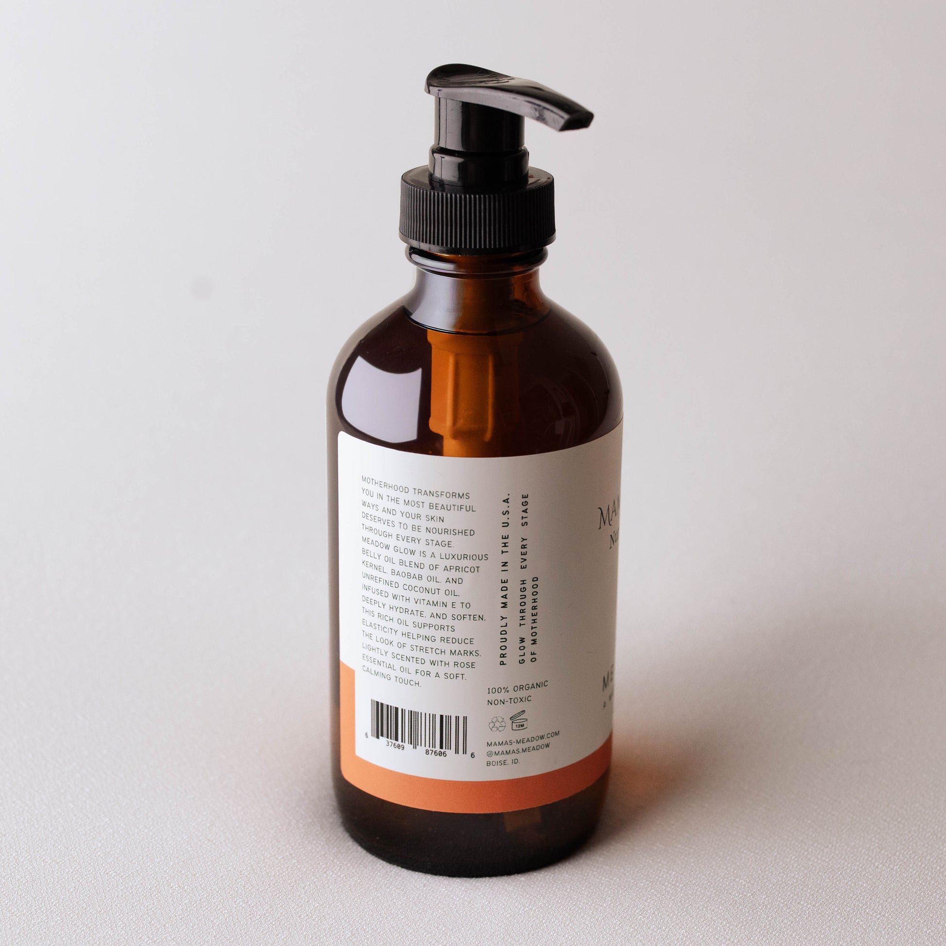 Brown bottle with pump dispenser on a light gray background