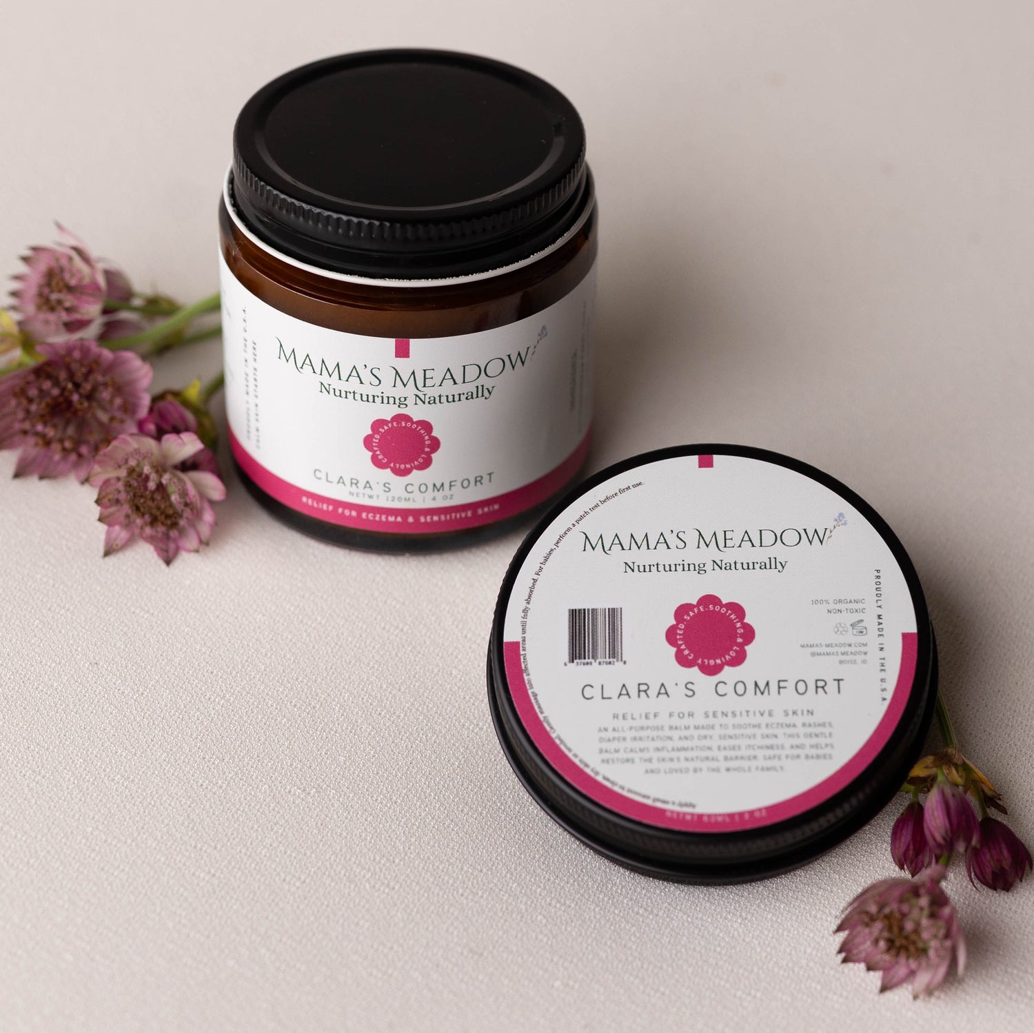 Two jars of 'Mama's Meadow' product on a light background with flowers.